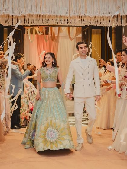 Another angle of the couple's joyful entry, showing the beautiful macrame and wicker decor hanging from the ceiling.