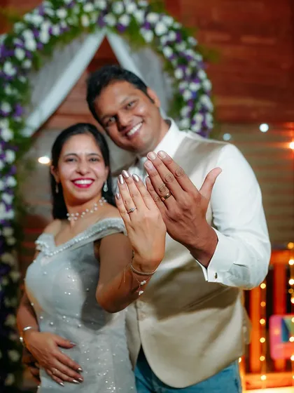 The happy couple showing off their new rings! This is a classic, joyful shot that celebrates their official engagement.