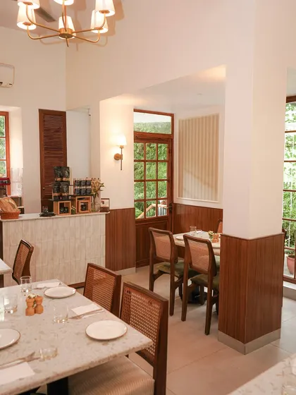The interior of our Vasant Vihar cafe, featuring clean lines, wood paneling, and comfortable seating. It's a bright and airy space perfect for any time of day.