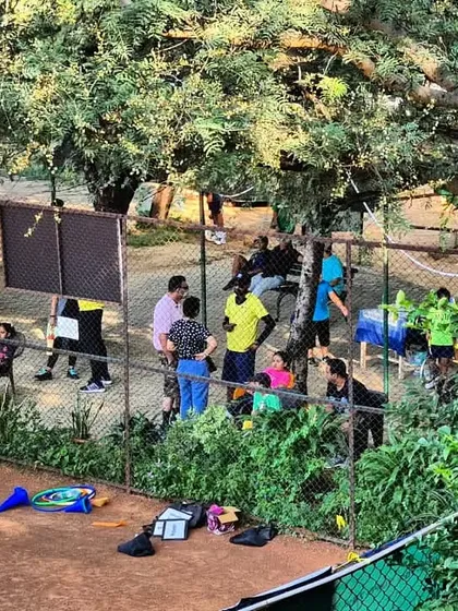 A view of the academy during a busy tournament weekend, with players, parents, and coaches gathered around the clay courts.