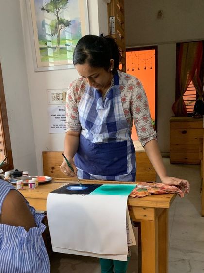 An instructor demonstrates how to create a smooth background wash in acrylics. This foundational skill is important for setting the mood of a painting.