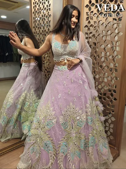 Perfect for a sangeet or a summer wedding, this pre-loved lavender lehenga is pure magic. The intricate peacock-inspired embroidery in pastel shades and the flowy skirt make it a true showstopper.