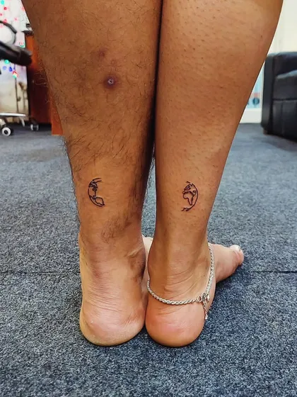 A matching couple's tattoo of the earth, split between two ankles. This minimalist design symbolizes being two halves of the same world.