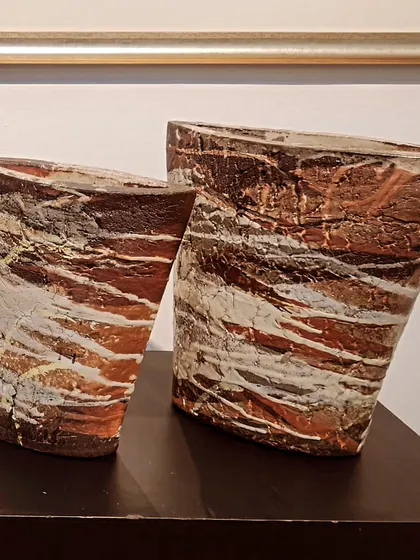 These two sculptural vases showcase a more rustic, artistic style. The textured surfaces and earthy tones are achieved through specific hand-building and firing techniques, making them unique statement pieces.