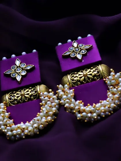 A slightly different angle of the handmade purple earrings, offering another clear view of their unique design and construction.