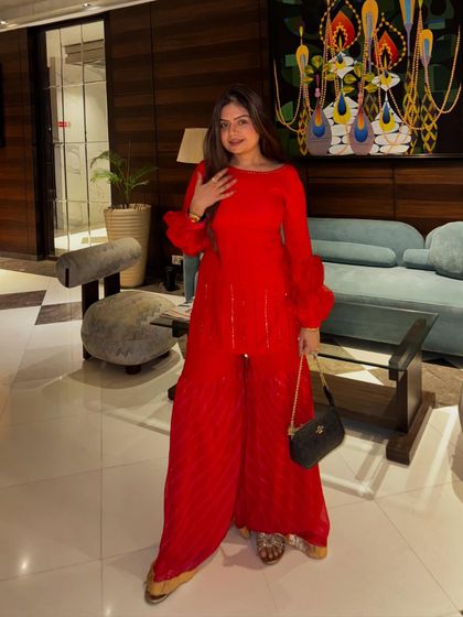 A bold red sharara set that's perfect for making a statement at any festive party. The monochrome look is both powerful and elegant.