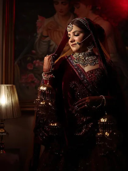 A dramatic, low-light portrait of the bride, her jewellery catching the light beautifully.