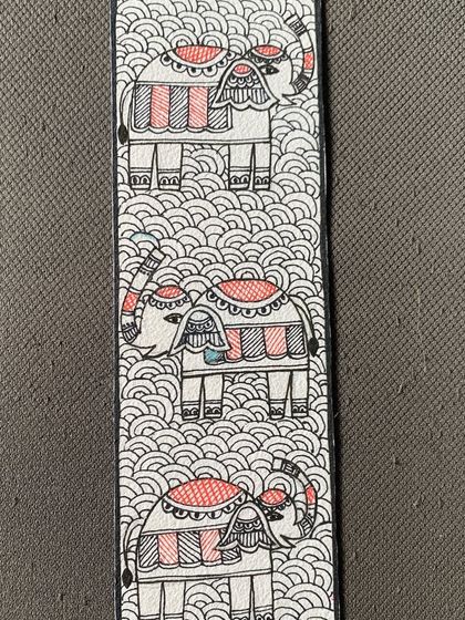 This Madhubani bookmark features a procession of elephants, a common symbol of prosperity and royalty. The dense patterns in the background are characteristic of the 'Bharni' style.