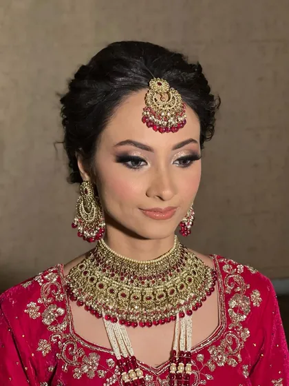 A side profile showcasing the elegant updo and the soft shimmer on the eyes. This look is all about timeless bridal beauty.