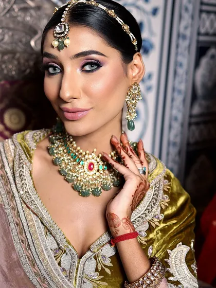 A full view of this bride's stunning look. The makeup, outfit, and jewellery all come together to create a look that is both regal and contemporary.