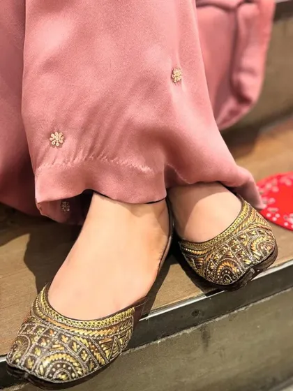 A pair of classic juttis with intricate brown and gold weaving, offering a timeless and versatile option for any ethnic outfit.