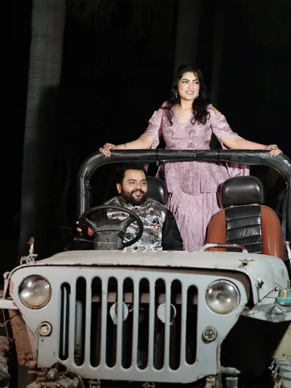 A stylish night shot with the vintage jeep, showcasing its versatility for both day and night photoshoots. The couple's pose adds a touch of glamour to the rugged prop.