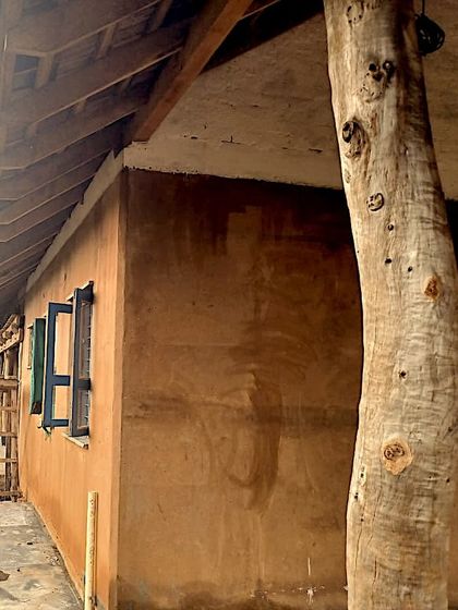 The exterior of the Unnathi Farm pavilion during construction, with its natural mud plaster and reclaimed wood columns.