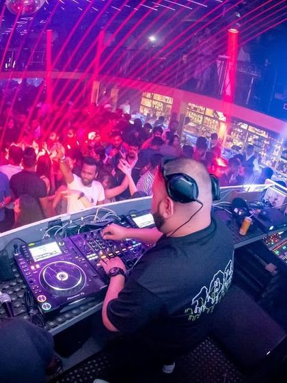 From my perspective at the DJ console in Wafira, Kolkata. It's a sea of people, lights, and energy, and I'm conducting it all with my music.