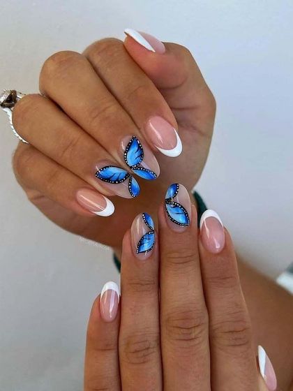 A classic French manicure with beautiful, hand-painted blue butterfly accents. This shows how to add a touch of delicate artistry to a simple base.
