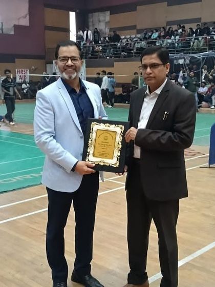 A guest of honor being felicitated with a plaque at the Inter-Faculty Tournament. Managing guest relations and formal acknowledgments is a seamless part of our service.