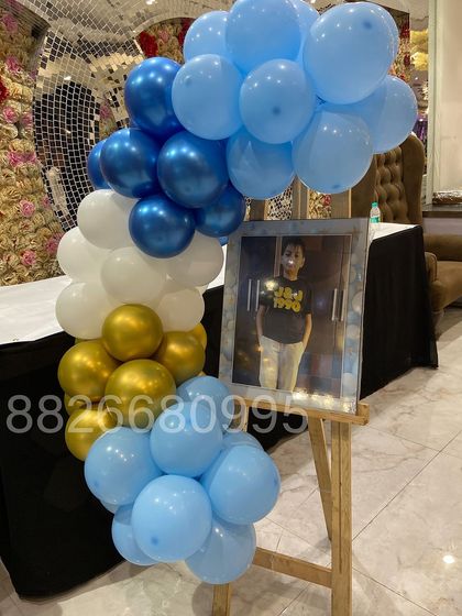 For a more intimate baby welcome celebration, I created this balloon arrangement to frame a photo on an easel. The combination of light blue, royal blue, white, and gold balloons adds a special touch to the display.