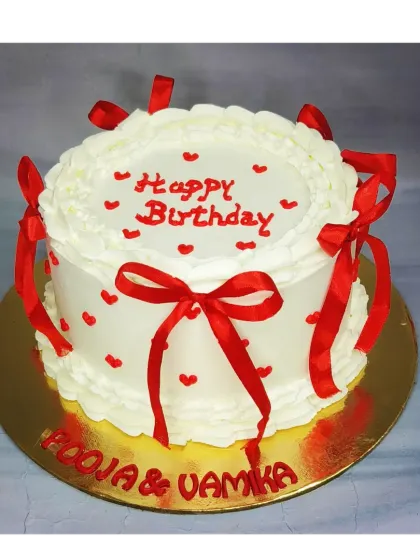 A classic vintage-style cake with red ribbon bows. This mixed fruit cake is perfect for a shared birthday celebration, offering a simple and timeless design.