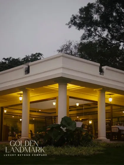As the sun sets, the Golden Landmark stands as a beacon of refined architecture. The classical columns and warm lighting create an atmosphere of serene elegance.