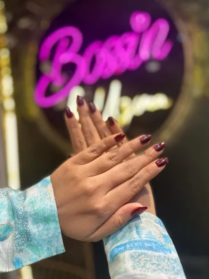 This manicure features a deep, glossy red polish on beautifully shaped almond nails. It's a classic, powerful color that exudes confidence.