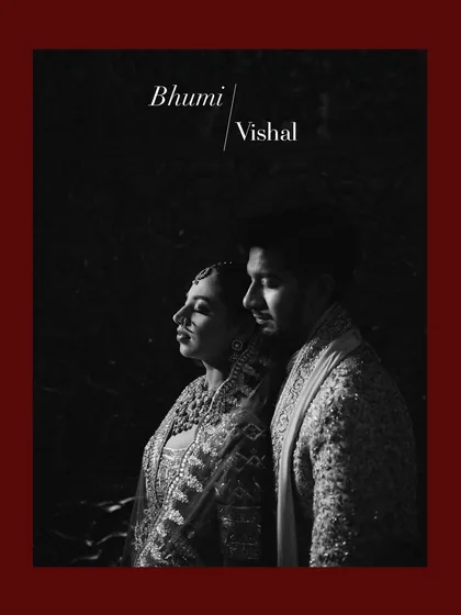 A powerful black and white portrait with deep shadows. The couple stands in a sliver of light, creating a dramatic and artistic image that highlights their profiles and the intensity of their connection.