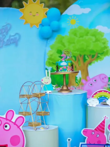 A detailed shot of a Peppa Pig themed dessert table, highlighting the character cutouts and themed props.