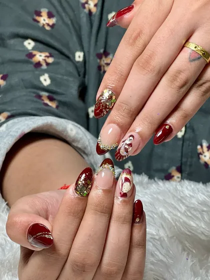 For our brides, we create truly one-of-a-kind nail art. This custom set for a wedding features a deep maroon base, sparkling glitter accents, and a hand-painted traditional bride design, making it a memorable part of the special day.