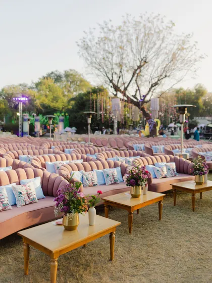 Rows of plush pink sofas with custom cushions provide ample and stylish seating for guests, combining comfort with a chic color palette.