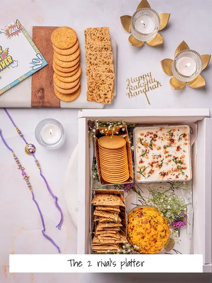 The '2 Rivals Platter' is for the siblings who love to share (or fight over) good food. This Rakhi hamper includes a cheese dome, a dip, and two types of crackers.