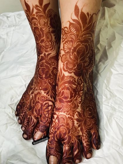A stunning, fully stained floral design covering both feet. The deep maroon color is a sign of high quality, natural henna.