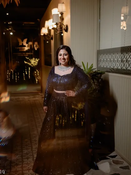 An artistic portrait of the bride with a slow shutter effect. The motion blur adds a dreamy and dynamic quality to the image, highlighting her sparkling blue lehenga.