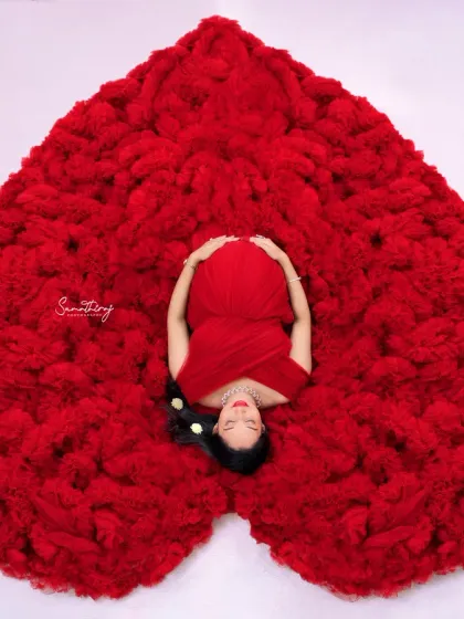 A creative top-down view of the heart-shaped gown pose. This artistic shot beautifully captures the shape and texture of the gown, with the mother-to-be at its center.