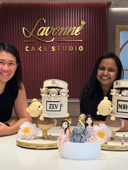 A proud moment with a client and our creations. We made two adorable teddy bear-themed cakes and a smaller one with an elephant and other cute figurines.