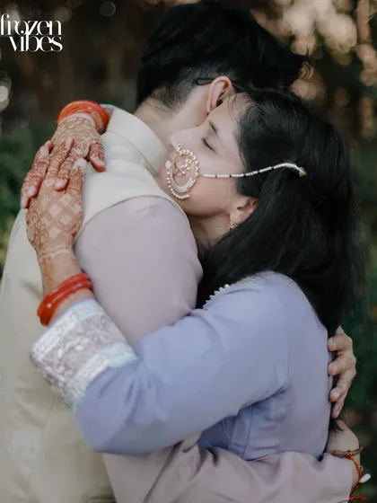 A beautiful close-up of Kanika hugging Abhinav, her eyes closed in a moment of peace and affection. The detail of her traditional nose ring adds a lovely cultural element.