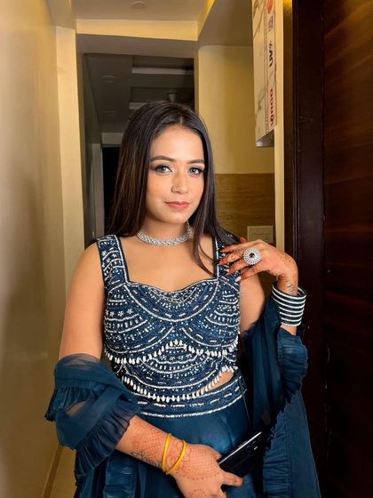 This client looks confident and beautiful in her rented dark blue lehenga, ready for the wedding festivities.