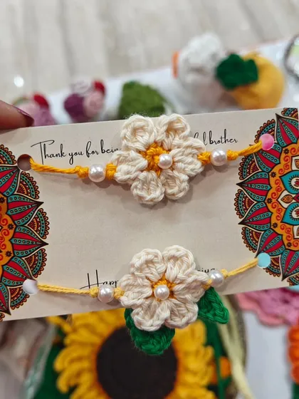 Simple and sweet crochet flower rakhis. These off-white flowers with a single pearl in the center are a classic and timeless design.