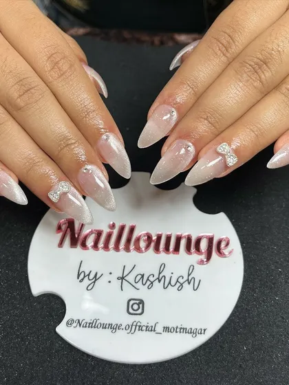 A beautiful 9D cat-eye effect on stiletto nails, giving a pearlescent, multi-dimensional look, finished with delicate rhinestone bows.