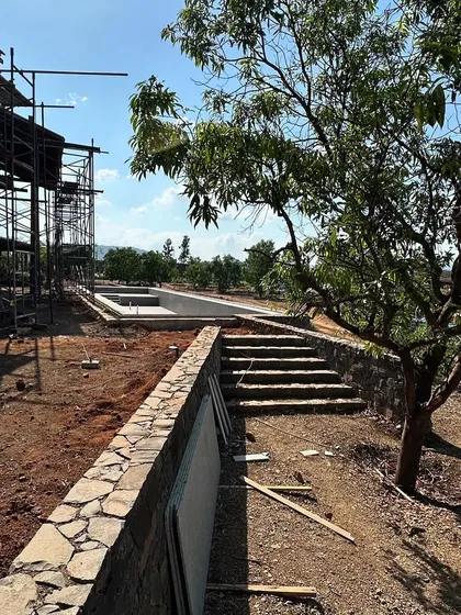 The retaining walls and swimming pool of the farmhouse are complete, ready for the surrounding landscape to be filled in. The design works with the natural slope of the land, creating different levels and terraces.