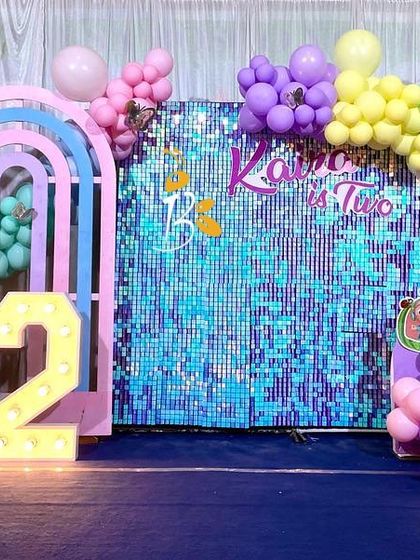 A colorful Cocomelon theme for Kaira's second birthday. We used a bright blue shimmer wall, rainbow-arched backdrops, and character cutouts to create a fun and playful party stage.