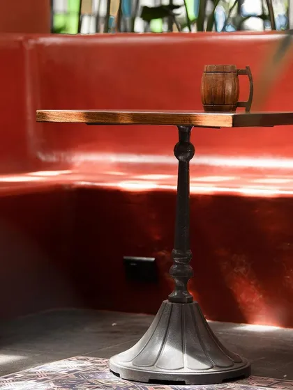 A close-up of a custom table at one of our restaurant projects. The cast-iron base and solid wood top are examples of the bespoke furniture we create in collaboration with vendors to ensure every detail is perfect.