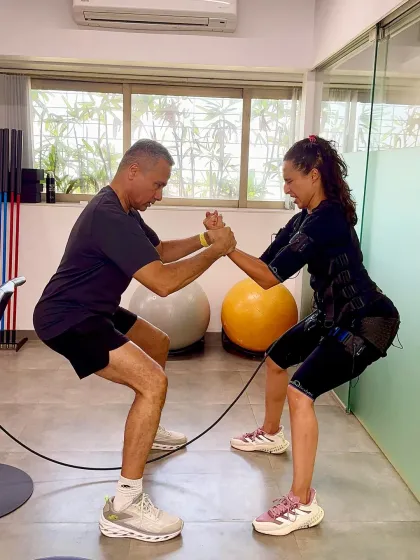 A father-daughter power duo demonstrates a partnered squat with EMS. This exercise builds lower body strength, enhances coordination, and shows that fitness is always better together.