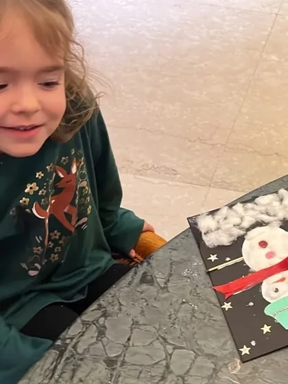 A student admires her handiwork after finishing her snowman card. It is wonderful to see the pride they take in their creations during our seasonal workshops.