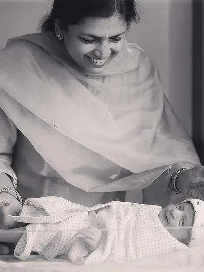 Grandparents are such an important part of the story. Here, a grandmother beams with love as she looks at her new grandchild for the first time in the hospital.