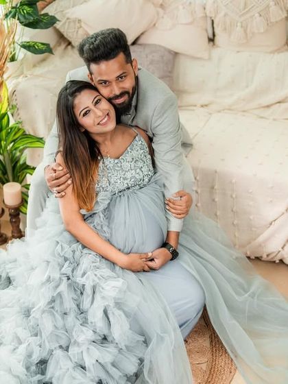 A comfortable and happy portrait of a couple in our boho studio. Seated on the floor, they embrace warmly, surrounded by soft textures and natural elements.