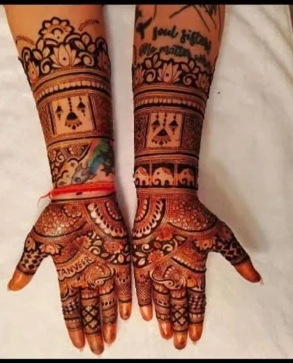 A unique design that combines traditional elephants and jharokha patterns with a modern touch. A colorful peacock feather tattoo on the wrist is beautifully incorporated into the overall henna design.