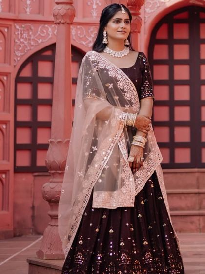 A sophisticated reception look. The bride wears a deep wine lehenga with mirror work, paired with a clean makeup look and simple, elegant diamond jewellery.
