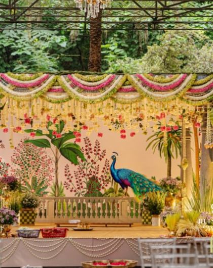 A detailed shot of the beautiful mandap we created for a traditional South Indian wedding. The combination of floral garlands, a painted backdrop, and the open-air glasshouse venue made for a truly memorable setting.