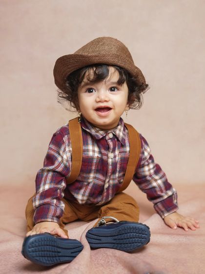 A bright and happy smile from a dapper little gentleman. We use various simple props, like this hat, to add character and fun to our classic baby portrait sessions.