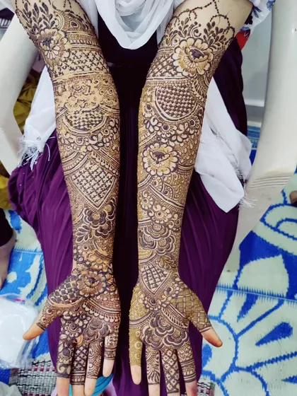 Beautifully intricate mehndi on a bride's hands, featuring a dense pattern that is perfect for a grand celebration.