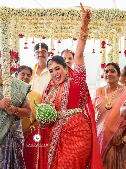 A joyful South Indian bride during her wedding ceremony. Her traditional hairstyle is beautifully done to withstand all the fun and rituals of the day.